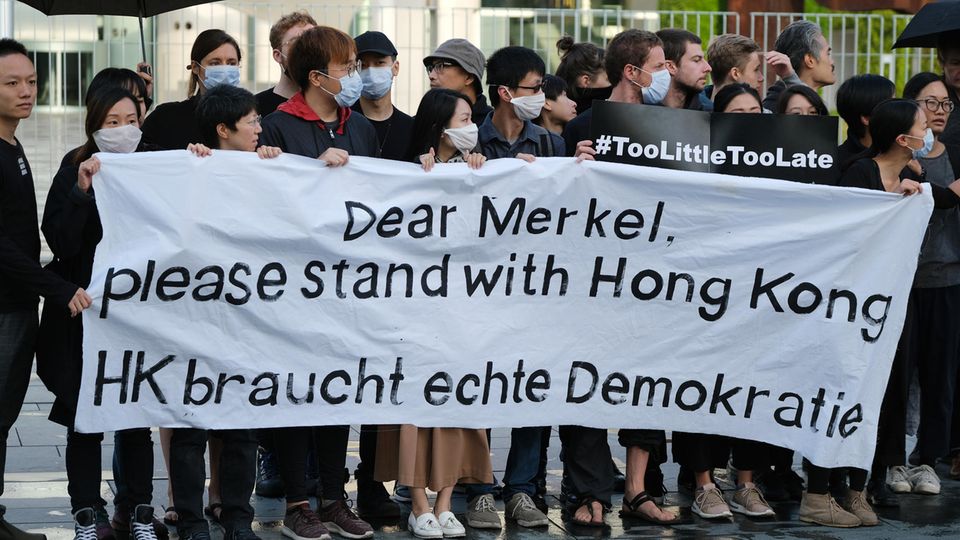Demonstranten bringen vor dem Reichstag in Berlin ihren Unmut darüber zum Ausdruck, dass Bundeskanzlerin Merkel bisher in Sachen Hongkong kein deutliches Signal gesendet hatte Demonstranten bringen vor dem Reichstag in Berlin