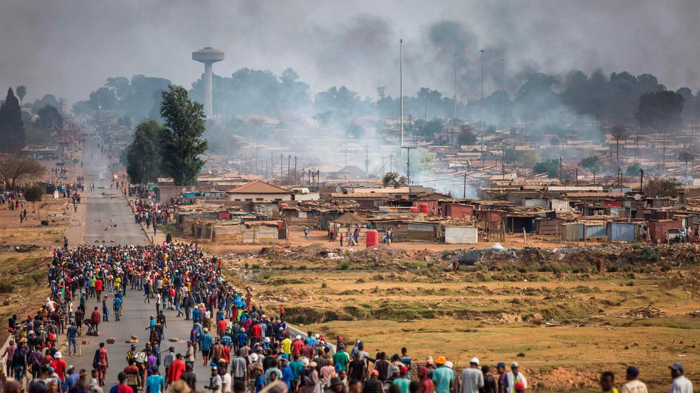 Ein bewaffneter Mob rennt während einer neuen Welle von Gewalt gegen Ausländer durch Johannesburgs Katlehong Township