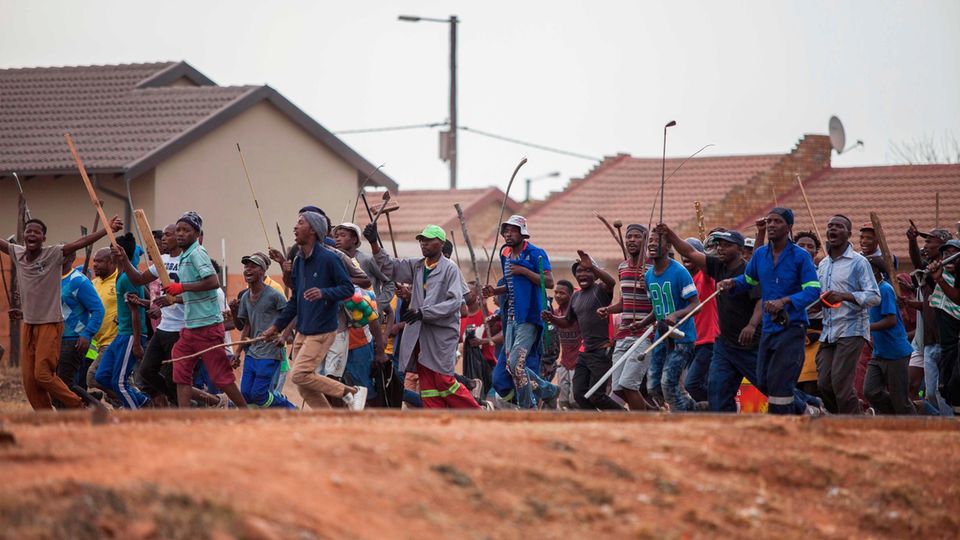Ein mit Speeren, Schlagstöcken und Äxten bewaffneter Mob rennt während einer neuen Welle von Gewalt gegen Ausländer durch Johannesburgs Katlehong Township Ein bewaffneter Mob rennt während einer neuen Welle von Gewalt gegen Ausländer durch Johannesburgs Katlehong Township