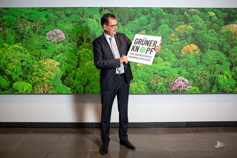 Entwicklungsminister Gerd Müller hält ein Schild mit der Aufschrift "Grüner Knopf" Entwicklungsminister Gerd Müller hält ein Schild mit der Aufschrift "Grüner Knopf"
