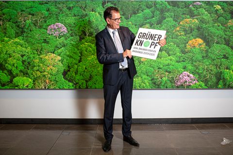 Entwicklungsminister Gerd Müller hält ein Schild mit der Aufschrift "Grüner Knopf"
