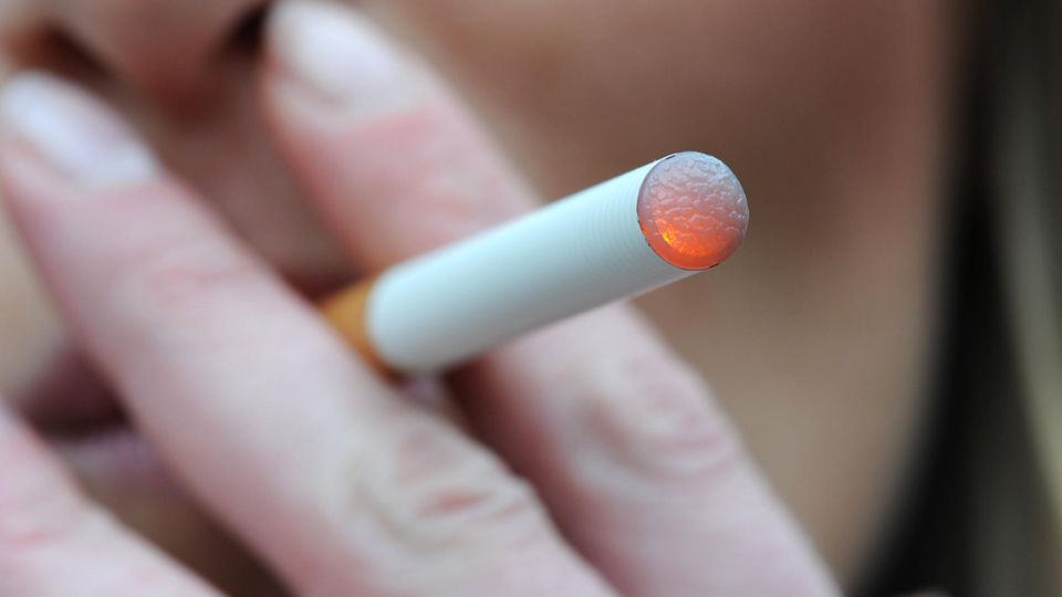 Eine Frau raucht am eine elektrische Zigarette