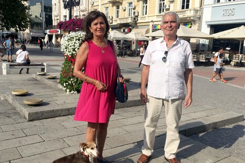 Die Friseurmeisterin Anna Holt (l) mit Hund Meggi und Werner Christes stehen auf einem Platz