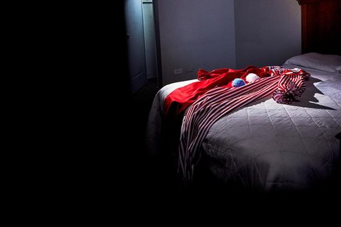 Symbolbild John Wayne Gacy: Ein Clownkostüm liegt auf einem Bett