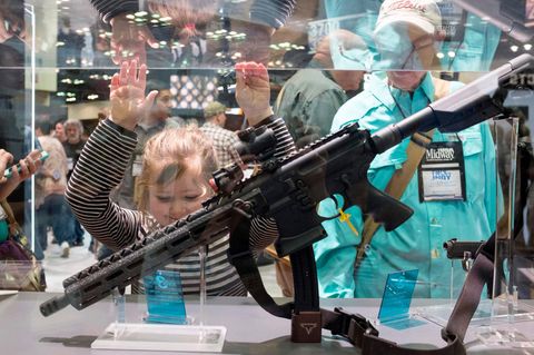 Ein junges Mädchen bestaunt auf dem jährlichen Treffen der NRA ein Gewehr.