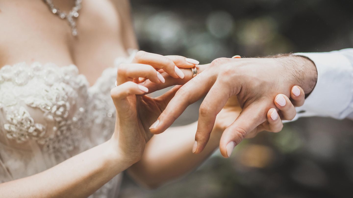 Hochzeit: Frau steckt Mann Ring an den Finger