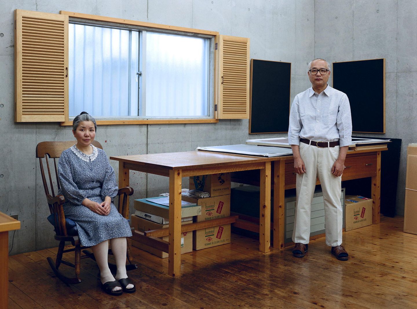 Eine Japanerin sitzt im Schaukelstuhl, ein Japaner steht in zwei Metern Entfernung
