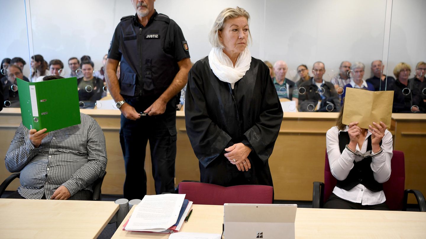 Mit verdeckten Gesichtern sitzen die Angeklagten zum Auftakt eines Mordprozesses im Gerichtssaal
