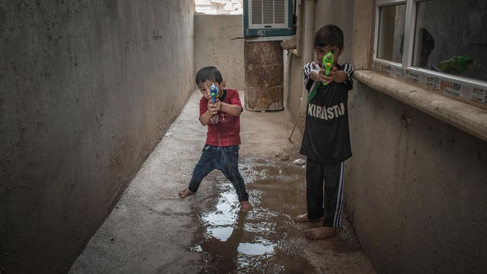 Khairi (links) spielt mit seinem älteren Bruder Aysar im Haus seines Onkels. Es wird viel gelacht aber auch hart verprügelt. Tränen gibt es kaum. Khairi und sein Bruder Anas (rechts) mit Wasserpistolen in den Händen. "Die Kinder haben alles mitansehen müssen", sagt Jaleela