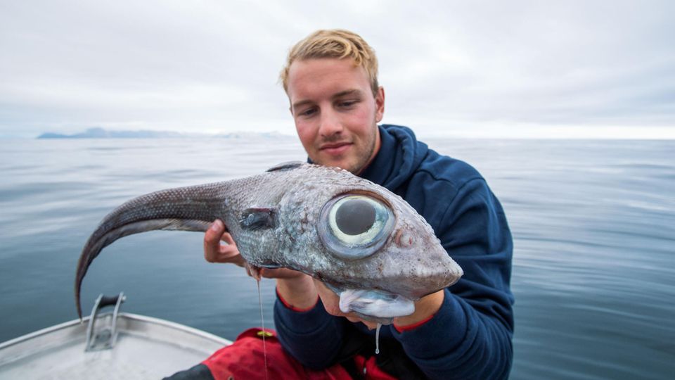 Fischer Oscar hält einen Fisch mit riesigen Glubschaugen in den Händen. 