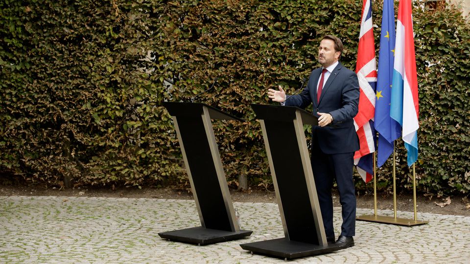 Xavier Bettel spricht auf einer Pressekonferenz neben einem leeren Rednerpult, das für Johnson gedacht war Xavier Bettel spricht auf einer Pressekonferenz neben einem leeren Rednerpult, das für Johnson gedacht war