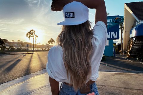 Model vor Sonnenuntergang mit weißer Cap