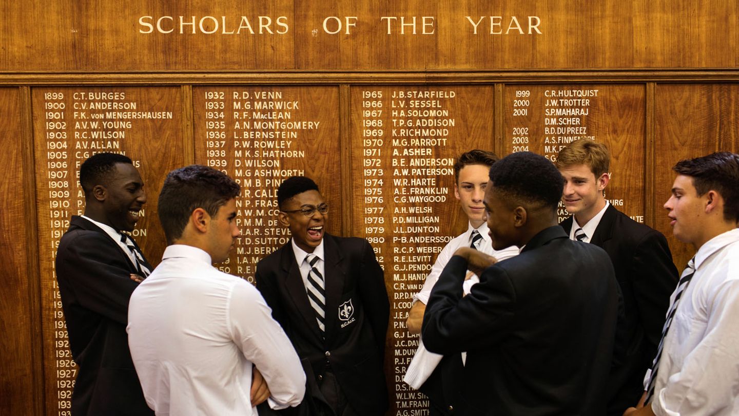 Am südafrikanischen Hilton College, einem Internat für Jungen, stehen Schüler vor einer Tafel und warten darauf, fotografiert zu werden. Die Schule steht für Diversität und Freundschaft, wie Schüler John Turner der Fotografin verrät: "Ich habe Freunde aus allen Lebensbereichen. In Ellis Haus gibt es farbige Jungen, Jungen verschiedener Religionen und Klassen in allen Schlafsälen und ich bin mit buchstäblich allen befreundet."