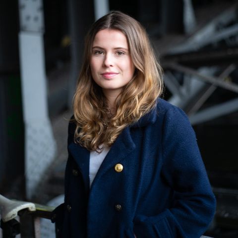 Luisa Neubauer trägt einen blauen Mantel und blickt in die Kamera