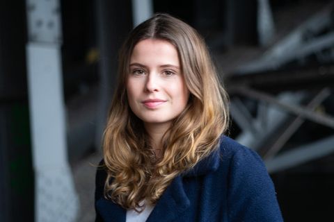 Luisa Neubauer trägt einen blauen Mantel und blickt in die Kamera