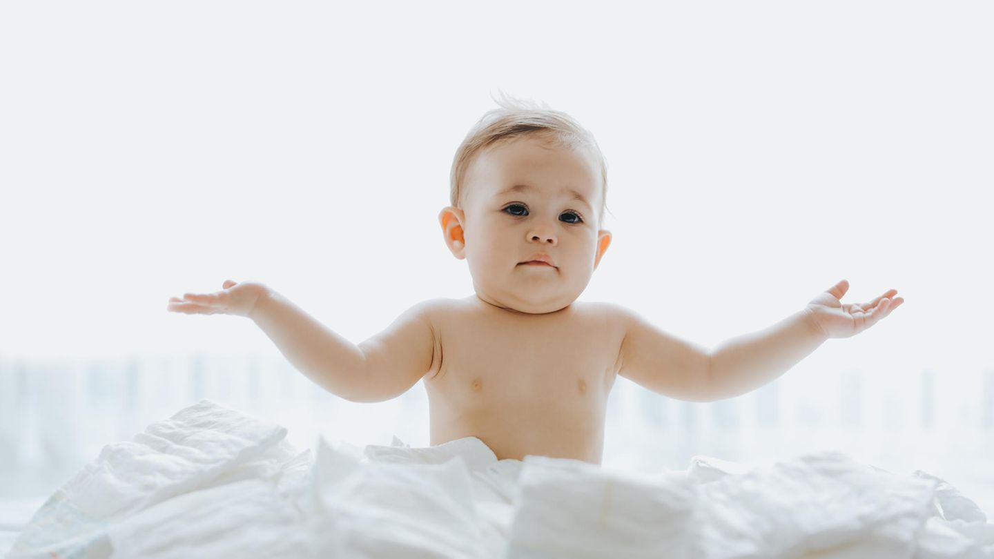 Ein Baby zuckt ahnungslos die Schultern