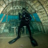 Hier steht ein Scuba Diver an der Stelle im Oberdeck, wo sich einst das Cockpit befand.