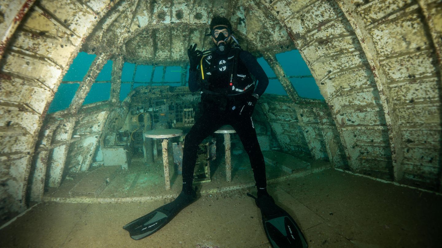 Hier steht ein Scuba Diver an der Stelle im Oberdeck, wo sich einst das Cockpit befand.