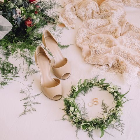 Braututensilien, wie ein Hochzeitskleid und Schuhe, liegen auf dem Boden