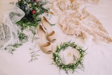 Braututensilien, wie ein Hochzeitskleid und Schuhe, liegen auf dem Boden