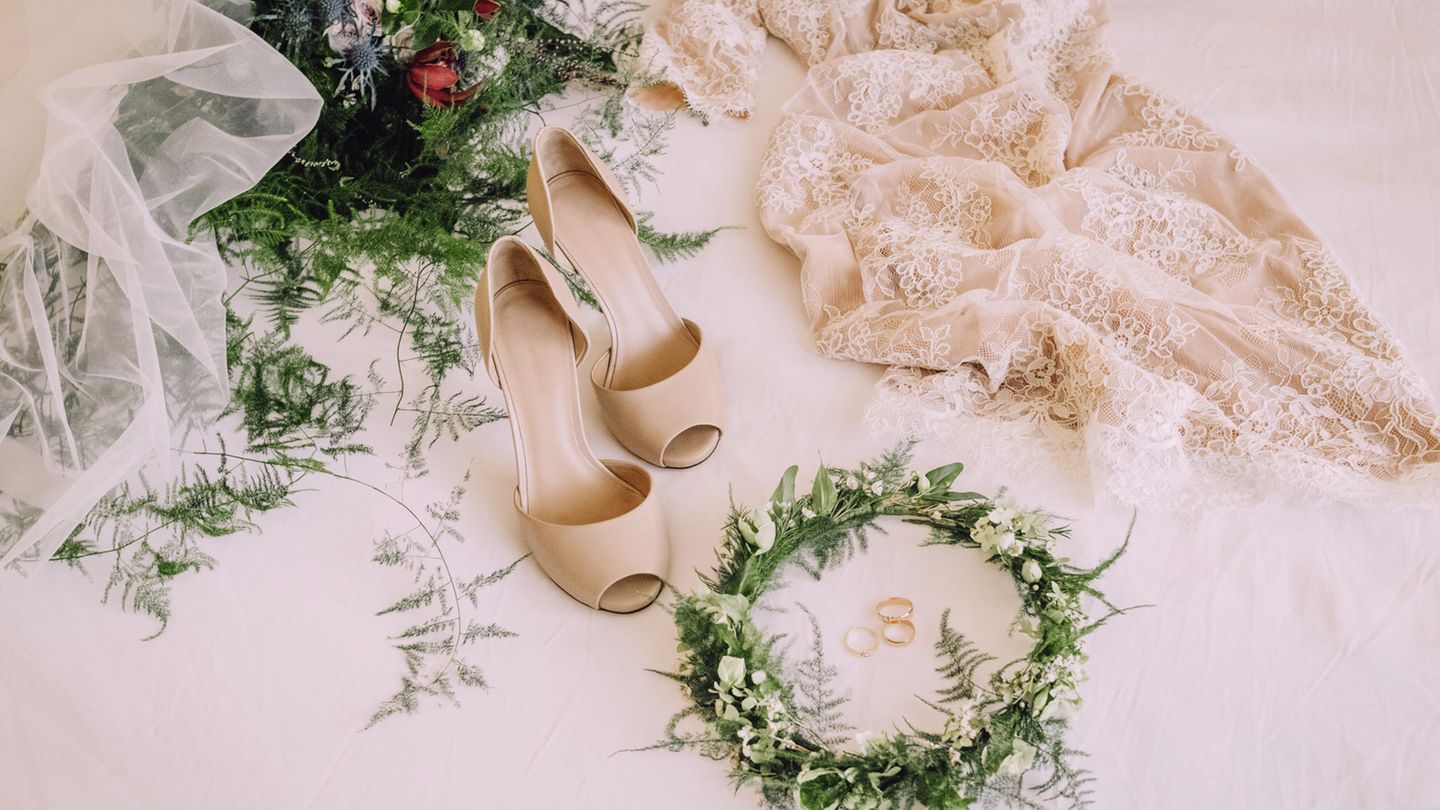 Braututensilien, wie ein Hochzeitskleid und Schuhe, liegen auf dem Boden