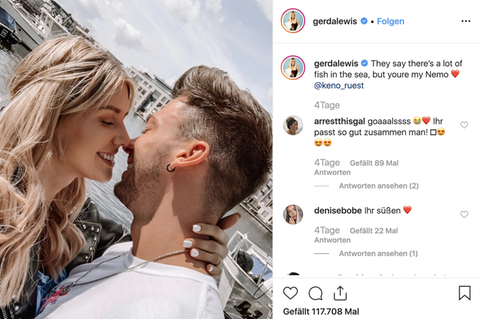 Eine blonde Frau zieht einen Mann mit braunem Seitenscheitel am Nacken zu sich. Beide lächeln und scheinen sich gleich zu küssen