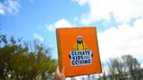 Australien, Canberra: Ein Demonstrant hält ein Schild mit einem Konterfei der schwedischen Schülerin und Klimaaktivistin Thunberg während einer Demonstration