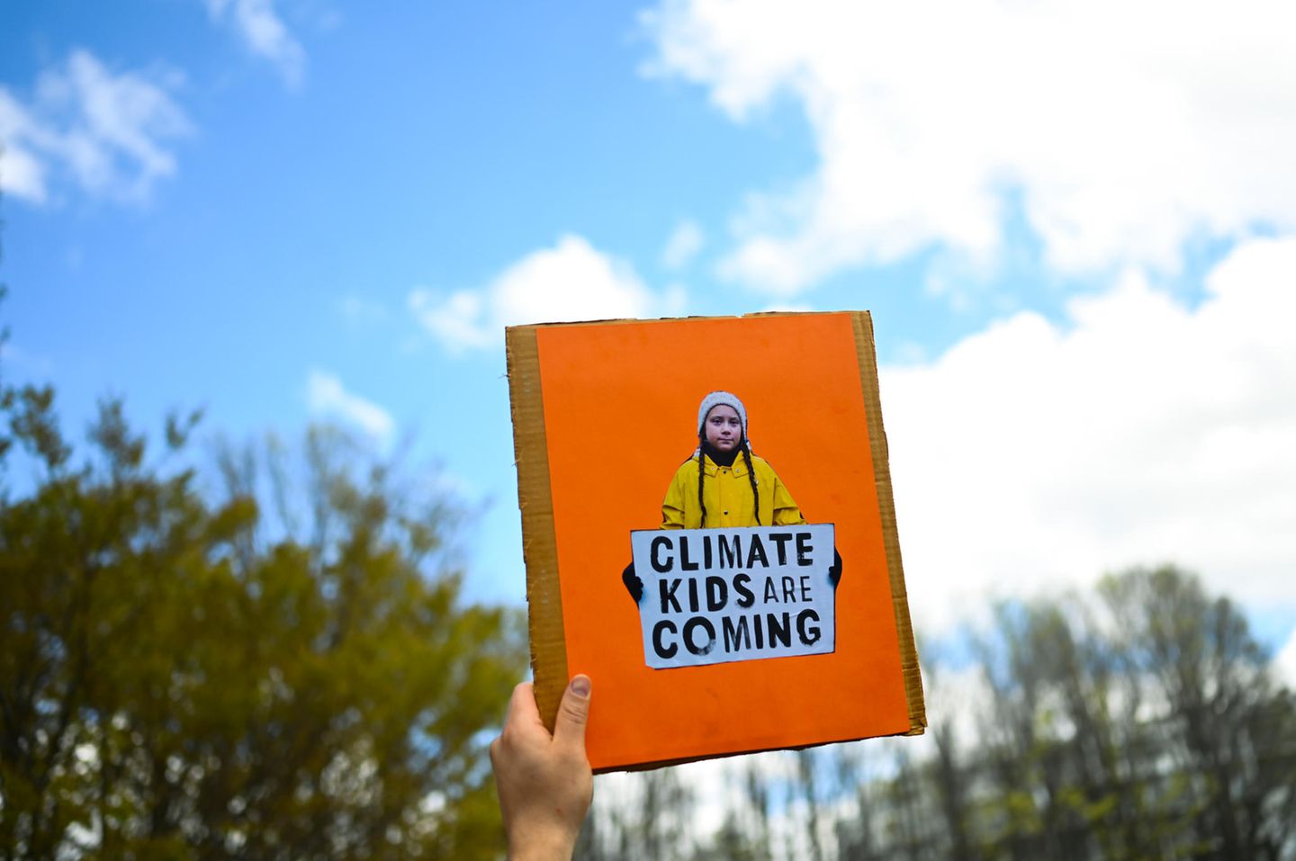 Australien, Canberra: Ein Demonstrant hält ein Schild mit einem Konterfei der schwedischen Schülerin und Klimaaktivistin Thunberg während einer Demonstration