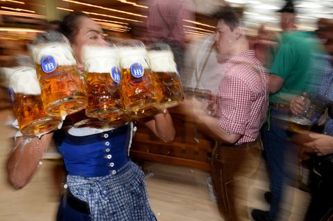 Eine Bedienung trägt volle Maßkrüge mit Bier auf dem Oktoberfest