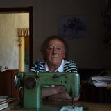 Eine alte Dame hinter einer Nähmaschine