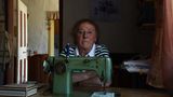 Eine alte Dame hinter einer Nähmaschine