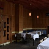 Ein holzvertäfelter Raum mit einer Reihe von Tischen und Stühlen