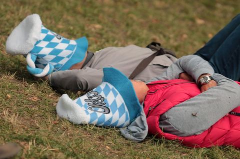 Besucher des Oktoberfestes schlafen auf dem berüchtigten "Kotzhügel" ihren Rausch aus