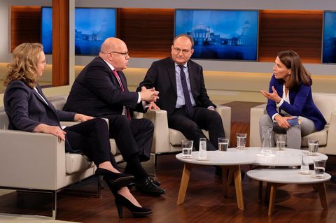 Moderatorin Anne Will beugt sich in der Diskussion zu ihrem Talkgast Peter Altmeier hinüber