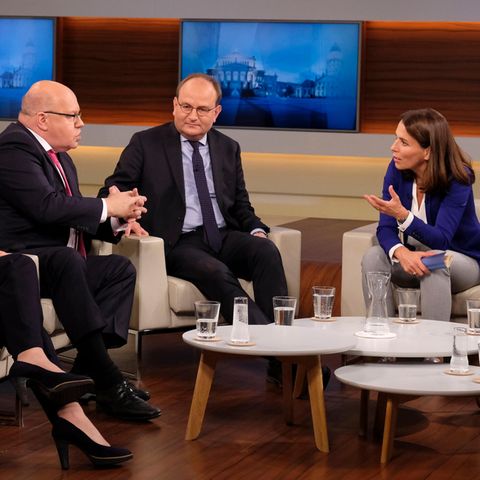 Moderatorin Anne Will beugt sich in der Diskussion zu ihrem Talkgast Peter Altmeier hinüber