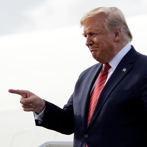 US-Präsident Donald Trump zeigt mit dem rechten Zeigefinger aur etwas, während er über eine Treppe sein Flugzeug verlässt