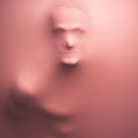 Gesicht eines Mannes, das sich durch rosa Lycrastoff abzeichnet