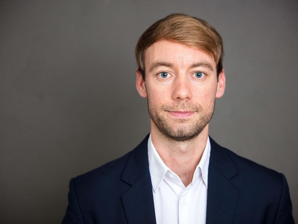Johannes Hillje Ein junger Mann mit blondem Seitenscheitel und in blauem Jackett lächelt in die Kamera