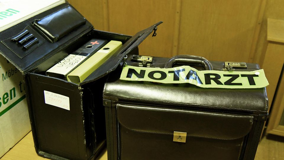 Urteil in Flensburg: Ein Koffer mit Notarzt-Abzeichen und weitere Beweismittel stehen beim Prozessauftakt im Gerichtssaal. Ein Koffer mit Notarzt-Abzeichen und weitere Beweismittel stehen beim Prozessauftakt im Gerichtssaal.