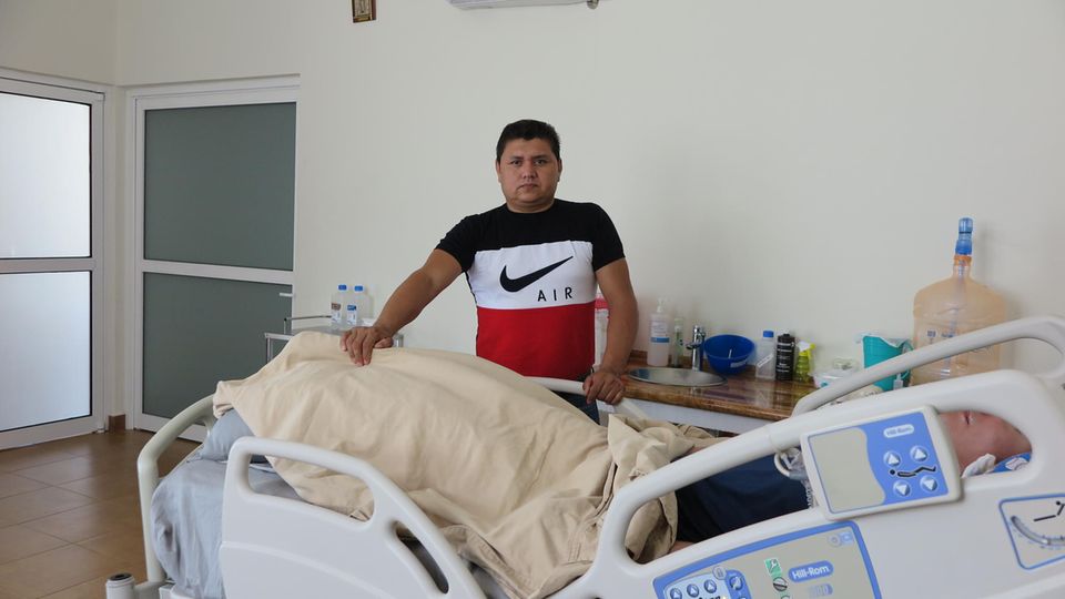 Leonel Gutiérrez Solano steht am Fuße des Bettes seines Bruders Aldo Leonel Gutiérrez Solano steht am Fuße des Bettes seines Bruders Aldo