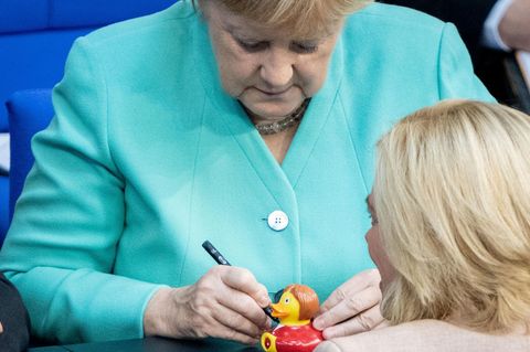 Bundeskanzlerin Angela Merkel unterschreibt eine Quietscheente