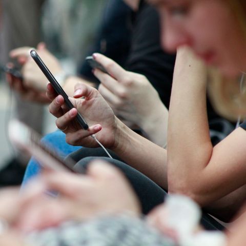 Nahaufnahme von vielen Händen, die Smartphones in der Hand halten