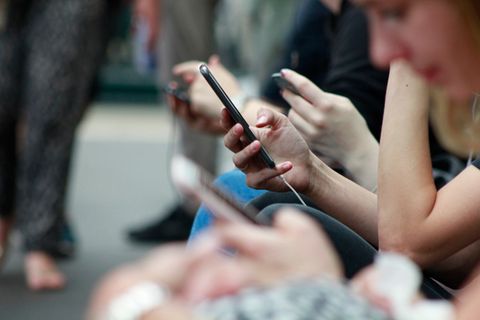 Nahaufnahme von vielen Händen, die Smartphones in der Hand halten