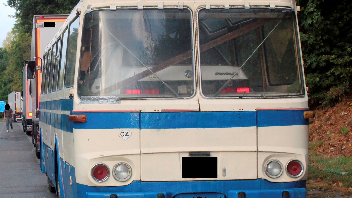 Ein weißer Passat steht im Innenraum eines weiß-blauen Reisebusses aus den 70er Jahren.