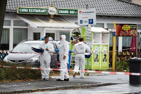 Drei Männer in weißen Overalls stehen vor einem China-Restaurant in Göttingen und sichern Spuren
