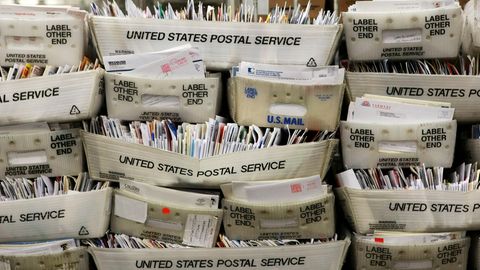 Hunderte Briefe stapeln sich in Postboxen.