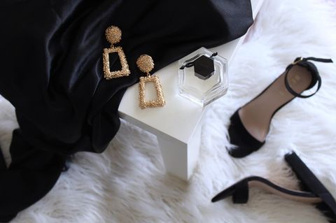 Kleid, Ohrringe und Schuhe liegen nebeneinander