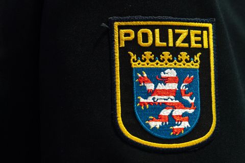 Auf dem Ärmel einer dunkelblauen Uniformjacke prangt das Wappen der Polizei Hessen