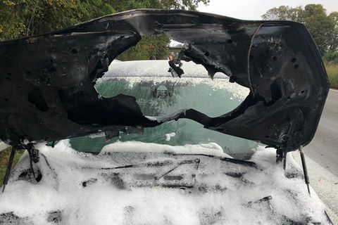 Ein Blick auf den Motorraum eines PKW, der nach erheblichen Brand mit Löschschaum bedeckt ist