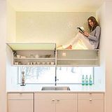 Frau sitzt auf Küchenschrank